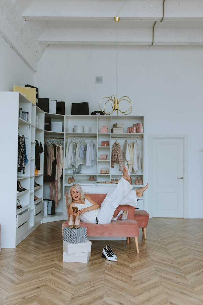 A joyful woman shopping online while lounging in her chic home wardrobe.